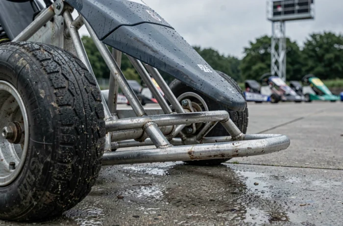 Detail des Chassis und der Reifen eines Mietkarts auf einem Paddock einer belgischen Strecke bei Regen